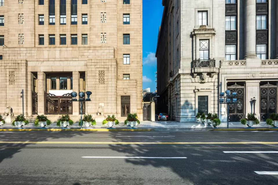 View from street of two neoclassical buildings with narrow alley between them.